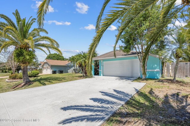 619 Dinner St NE, Palm Bay, FL 32907 - view of front of property with a garage, driveway, fence, and a front yard