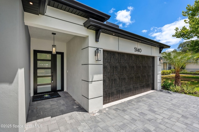 property entrance featuring driveway and stucco siding