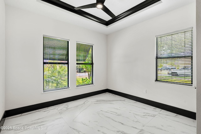 unfurnished room with plenty of natural light, marble finish floor, baseboards, and ceiling fan