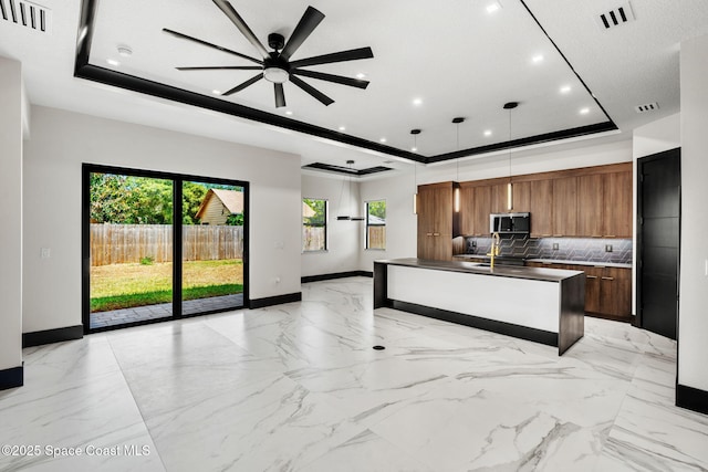 kitchen with a raised ceiling, modern cabinets, visible vents, and stainless steel microwave
