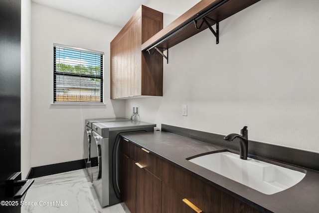laundry area featuring independent washer and dryer, baseboards, marble finish floor, a sink, and cabinet space
