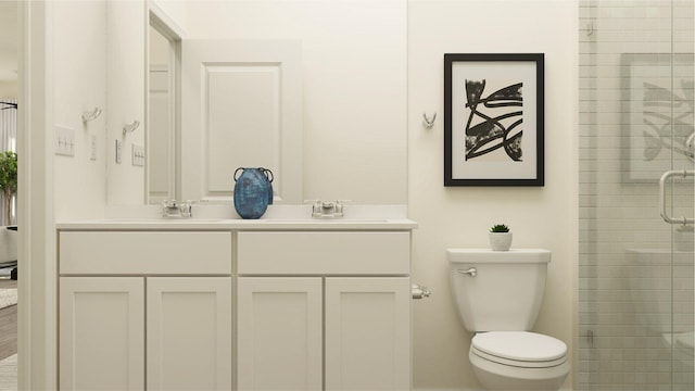 bathroom featuring toilet, double vanity, a sink, and a shower stall