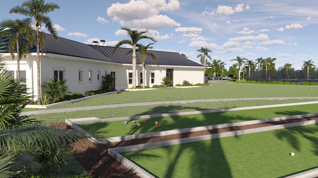view of front of property with metal roof, fence, stucco siding, and a standing seam roof