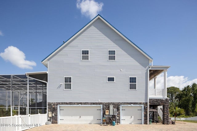3824 Luxury Ln, Titusville, FL 32796 - rear view of property with stone siding, a garage, and driveway