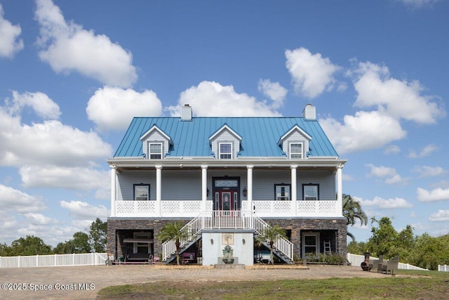 3824 Luxury Ln, Titusville, FL 32796 - coastal inspired home with a chimney, a standing seam roof, and stairs