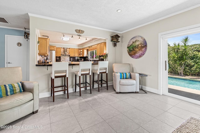 190 Harwood Ave, Satellite Beach, FL 32937 - living room featuring crown molding, healthy amount of natural light, a textured ceiling, light tile patterned floors, and baseboards