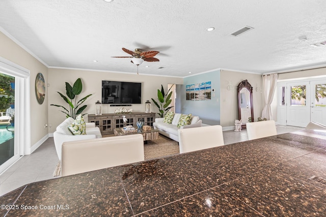 190 Harwood Ave, Satellite Beach, FL 32937 - living area with baseboards, a textured ceiling, tile patterned flooring, a ceiling fan, and crown molding