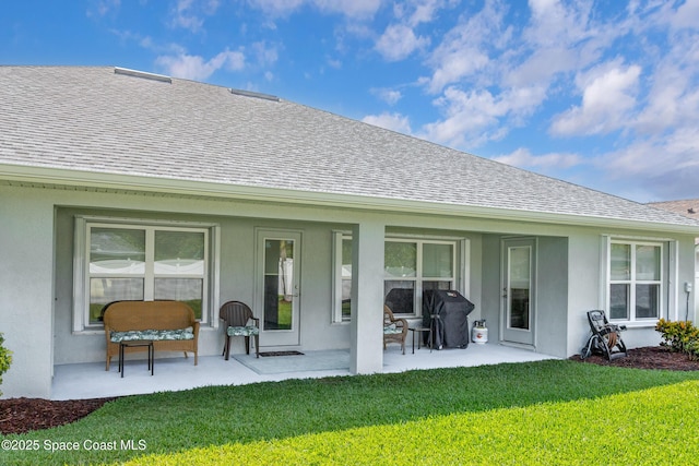 4569 Lady Hawk Way, Melbourne, FL 32904 - rear view of property featuring roof with shingles, a yard, a patio area, and stucco siding