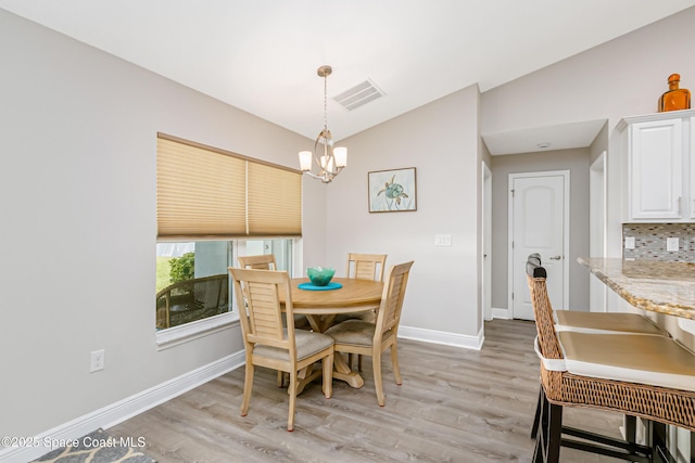 4569 Lady Hawk Way, Melbourne, FL 32904 - dining space featuring lofted ceiling, baseboards, light wood-type flooring, and a chandelier