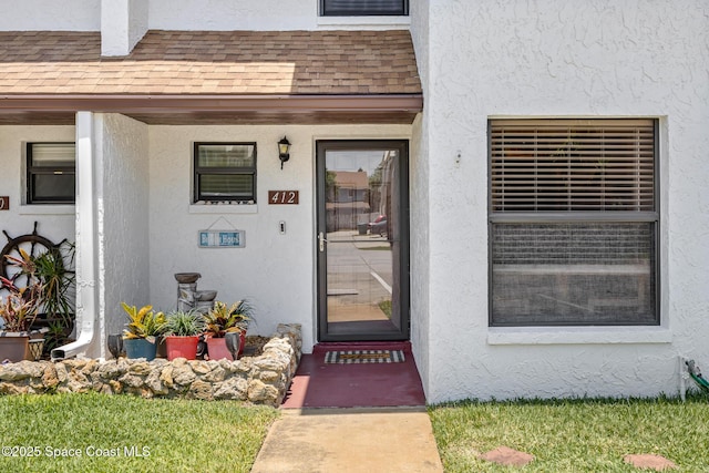 412 Sailfish Ave Unit 16, Cape Canaveral, FL 32920 - doorway to property with stucco siding and a shingled roof