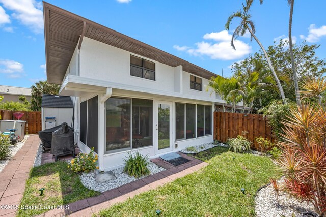 412 Sailfish Ave Unit 16, Cape Canaveral, FL 32920 - rear view of property with fence and a sunroom