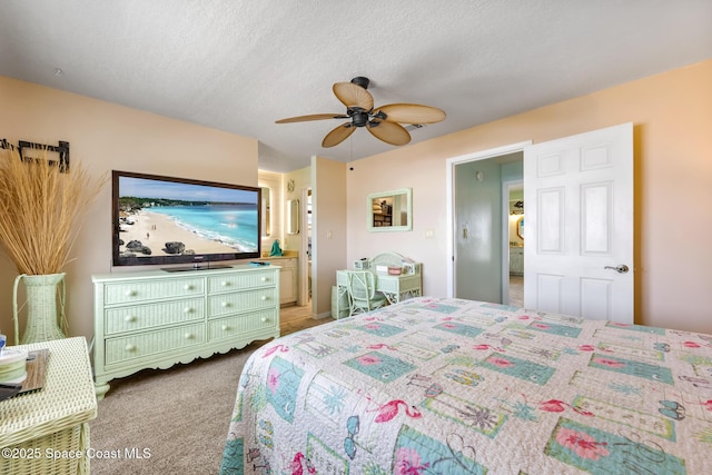 412 Sailfish Ave Unit 16, Cape Canaveral, FL 32920 - bedroom with light colored carpet, ceiling fan, ensuite bath, and a textured ceiling