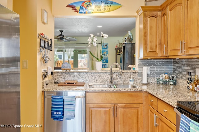 412 Sailfish Ave Unit 16, Cape Canaveral, FL 32920 - kitchen featuring appliances with stainless steel finishes, a sink, a ceiling fan, decorative backsplash, and light stone countertops