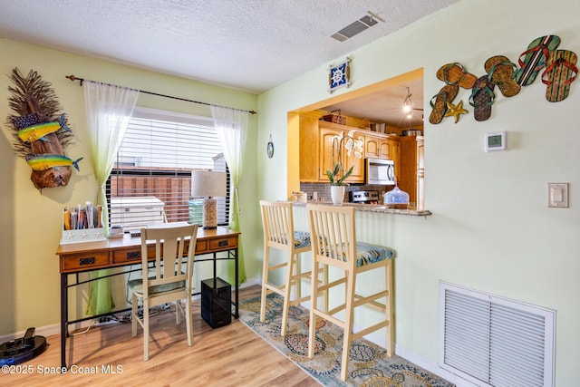 412 Sailfish Ave Unit 16, Cape Canaveral, FL 32920 - office area featuring light wood-style flooring, a textured ceiling, and baseboards
