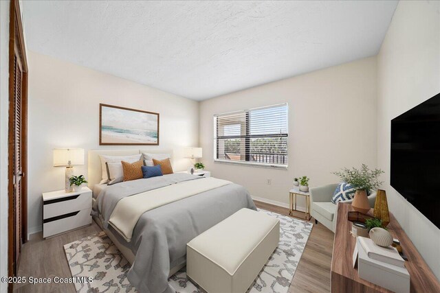 1950 Atlantic St Unit 223, Melbourne Beach, FL 32951 - bedroom with baseboards, light wood-type flooring, and a textured ceiling
