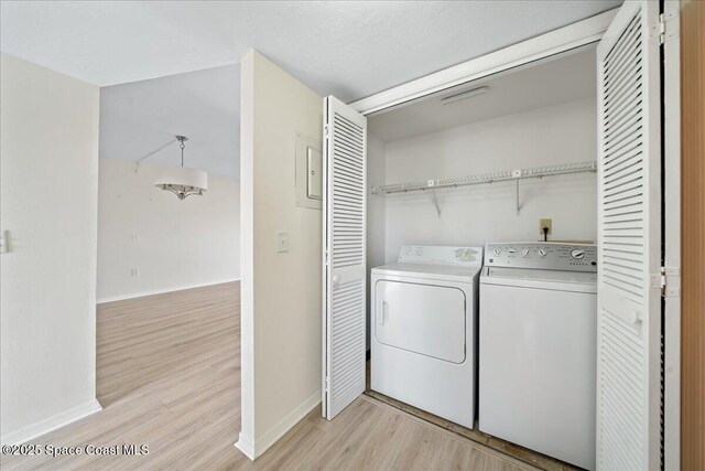 1950 Atlantic St Unit 223, Melbourne Beach, FL 32951 - washroom with baseboards, light wood-style flooring, and separate washer and dryer