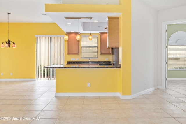3547 Plume Way, Palm Bay, FL 32909 - kitchen with hanging light fixtures, baseboards, dark countertops, and plenty of natural light