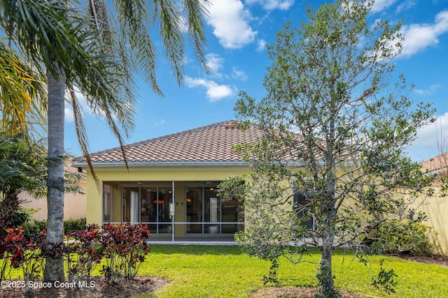 3547 Plume Way, Palm Bay, FL 32909 - rear view of house featuring a lawn, a sunroom, stucco siding, and a tiled roof