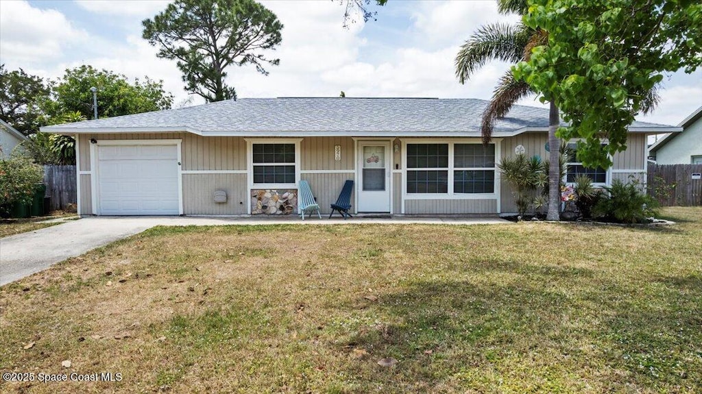 ranch-style home featuring a front yard, driveway, fence, and a garage