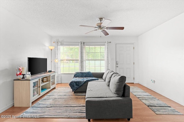 5970 Coker Ave, Cocoa, FL 32927 - living area with a textured ceiling, wood finished floors, a ceiling fan, and baseboards