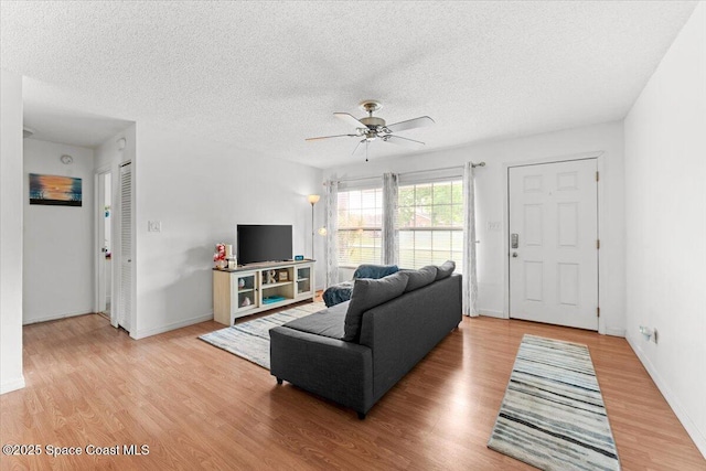 5970 Coker Ave, Cocoa, FL 32927 - living area featuring a textured ceiling, a ceiling fan, light wood finished floors, and baseboards