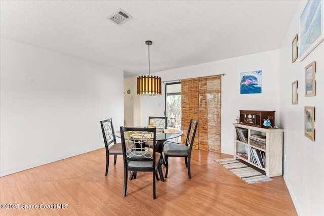 5970 Coker Ave, Cocoa, FL 32927 - dining space featuring light wood-type flooring, a textured ceiling, and baseboards
