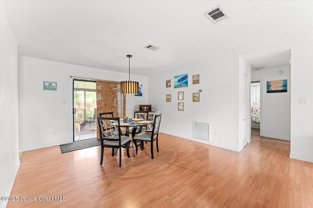 5970 Coker Ave, Cocoa, FL 32927 - dining area with light wood-style flooring, baseboards, and a textured ceiling