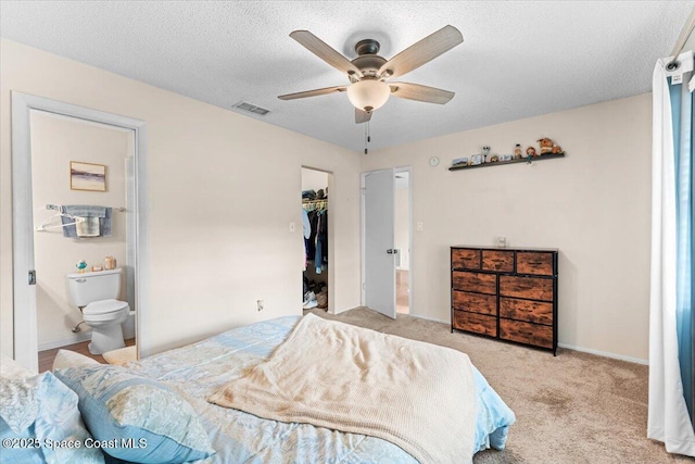 5970 Coker Ave, Cocoa, FL 32927 - carpeted bedroom with a walk in closet, a textured ceiling, connected bathroom, a ceiling fan, and a closet