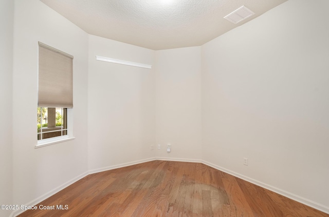 unfurnished room with wood finished floors and baseboards