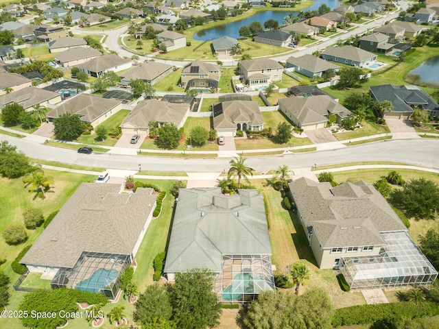aerial view of property and surrounding area featuring nearby suburban area and a large body of water