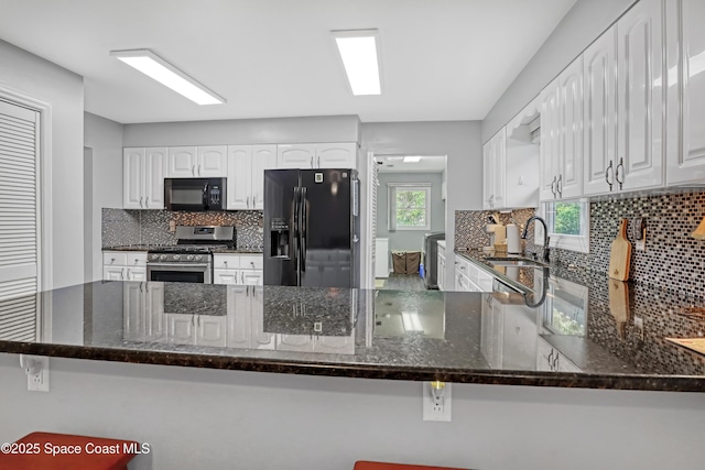 5280 Curtis Blvd, Cocoa, FL 32927 - kitchen with black appliances, backsplash, dark stone counters, and white cabinetry