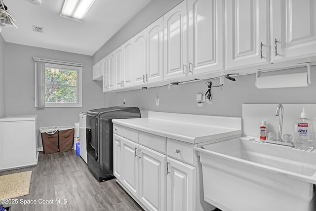 5280 Curtis Blvd, Cocoa, FL 32927 - washroom featuring cabinet space, washing machine and dryer, and light wood-type flooring