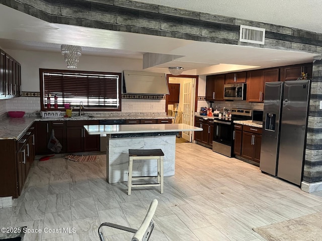 797 James Cir, Palm Bay, FL 32905 - kitchen with appliances with stainless steel finishes, a sink, tasteful backsplash, a kitchen island, and dark brown cabinetry