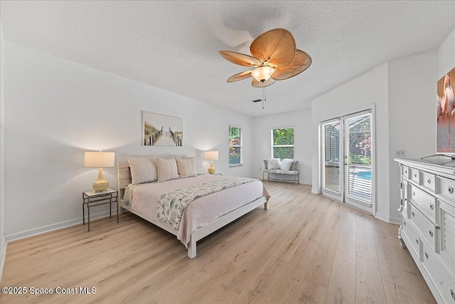 1085 Mercedes Dr, Merritt Island, FL 32952 - bedroom with access to exterior, light wood finished floors, baseboards, ceiling fan, and a textured ceiling
