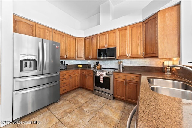 1085 Mercedes Dr, Merritt Island, FL 32952 - kitchen with appliances with stainless steel finishes, a sink, brown cabinets, and light tile patterned floors