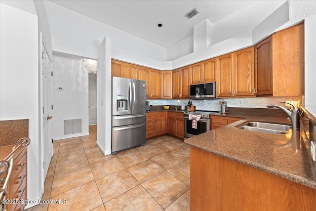1085 Mercedes Dr, Merritt Island, FL 32952 - kitchen featuring stainless steel appliances, a sink, brown cabinetry, tasteful backsplash, and light tile patterned floors
