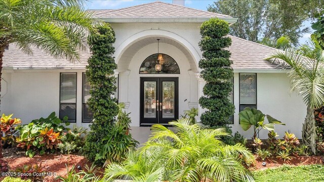 1085 Mercedes Dr, Merritt Island, FL 32952 - entrance to property with french doors, a shingled roof, and stucco siding