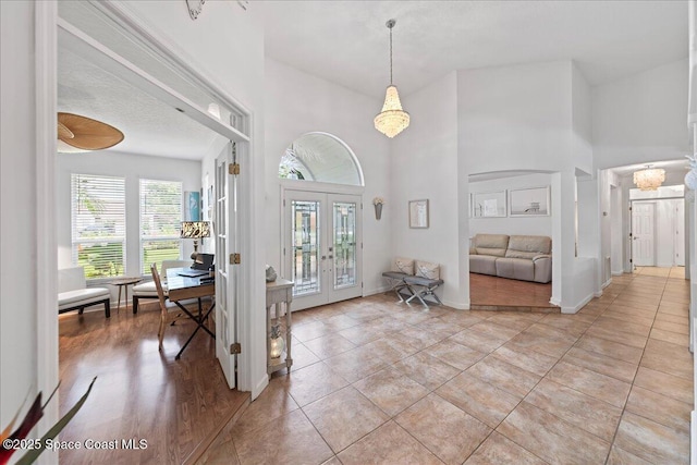 1085 Mercedes Dr, Merritt Island, FL 32952 - foyer with a towering ceiling, french doors, a chandelier, and baseboards