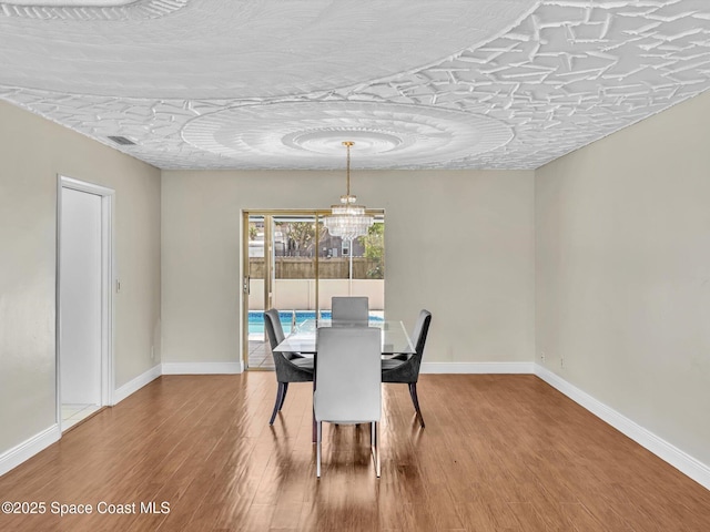 5118 Adams St, Hollywood, FL 33021 - dining area with wood finished floors, baseboards, and a chandelier