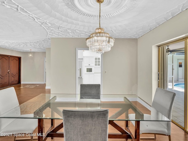 5118 Adams St, Hollywood, FL 33021 - unfurnished dining area featuring a chandelier, baseboards, and wood finished floors