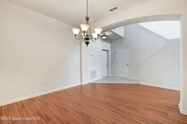 3202 Arden Cir, Melbourne, FL 32934 - unfurnished dining area with a chandelier, light wood-style floors, baseboards, and arched walkways