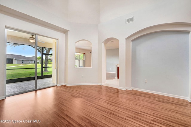 3202 Arden Cir, Melbourne, FL 32934 - unfurnished living room with arched walkways, a ceiling fan, wood finished floors, and baseboards