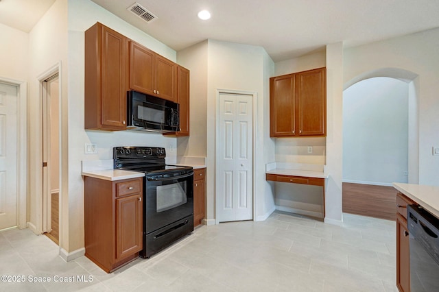 3202 Arden Cir, Melbourne, FL 32934 - kitchen with black appliances, light countertops, arched walkways, brown cabinets, and recessed lighting