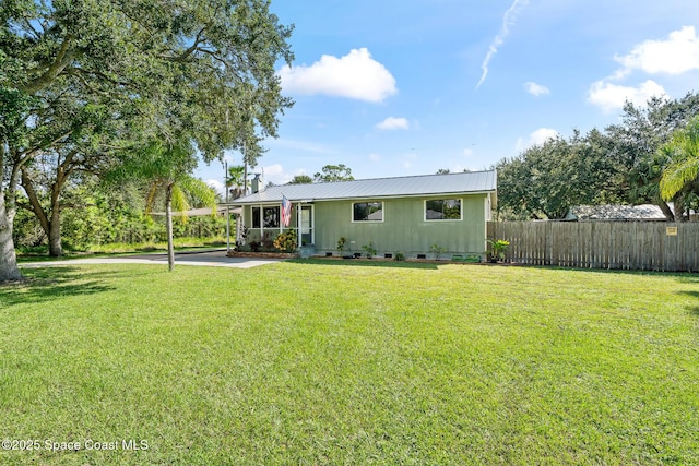9633 Honeysuckle Dr, Sebastian, FL 32976 - single story home with metal roof, a front lawn, and fence