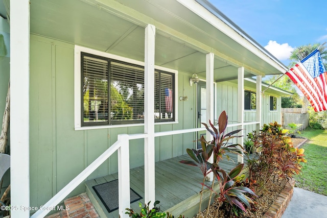 9633 Honeysuckle Dr, Sebastian, FL 32976 - doorway to property featuring board and batten siding and covered porch