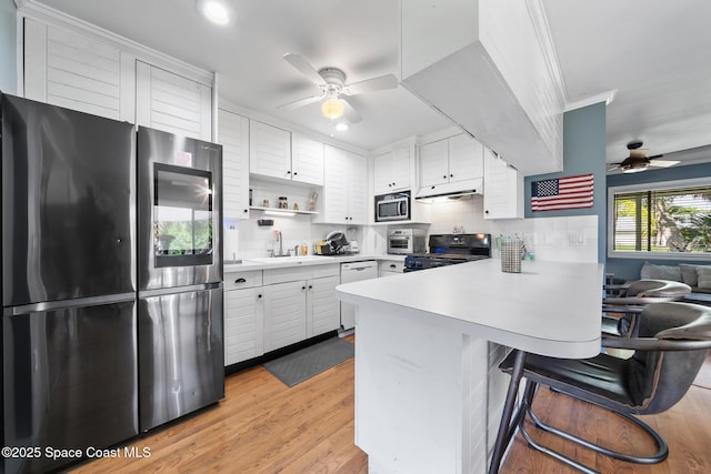 9633 Honeysuckle Dr, Sebastian, FL 32976 - kitchen with a peninsula, stainless steel appliances, ceiling fan, and a sink