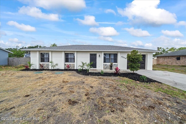 ranch-style home with a garage, concrete driveway, stucco siding, and fence