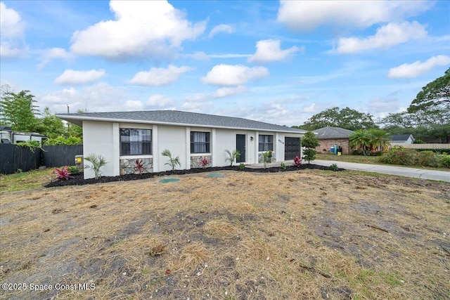 ranch-style house with an attached garage, fence, stucco siding, and driveway
