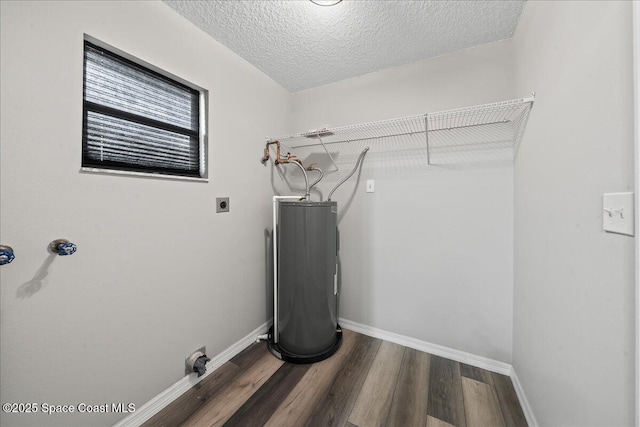 clothes washing area with hookup for an electric dryer, wood finished floors, baseboards, water heater, and a textured ceiling