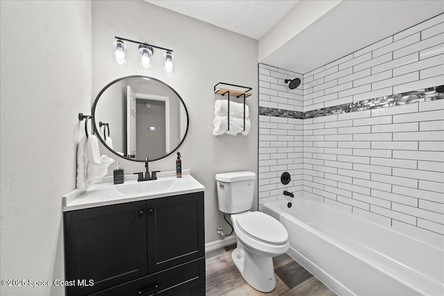 full bathroom with wood finished floors, toilet, vanity, shower / washtub combination, and baseboards